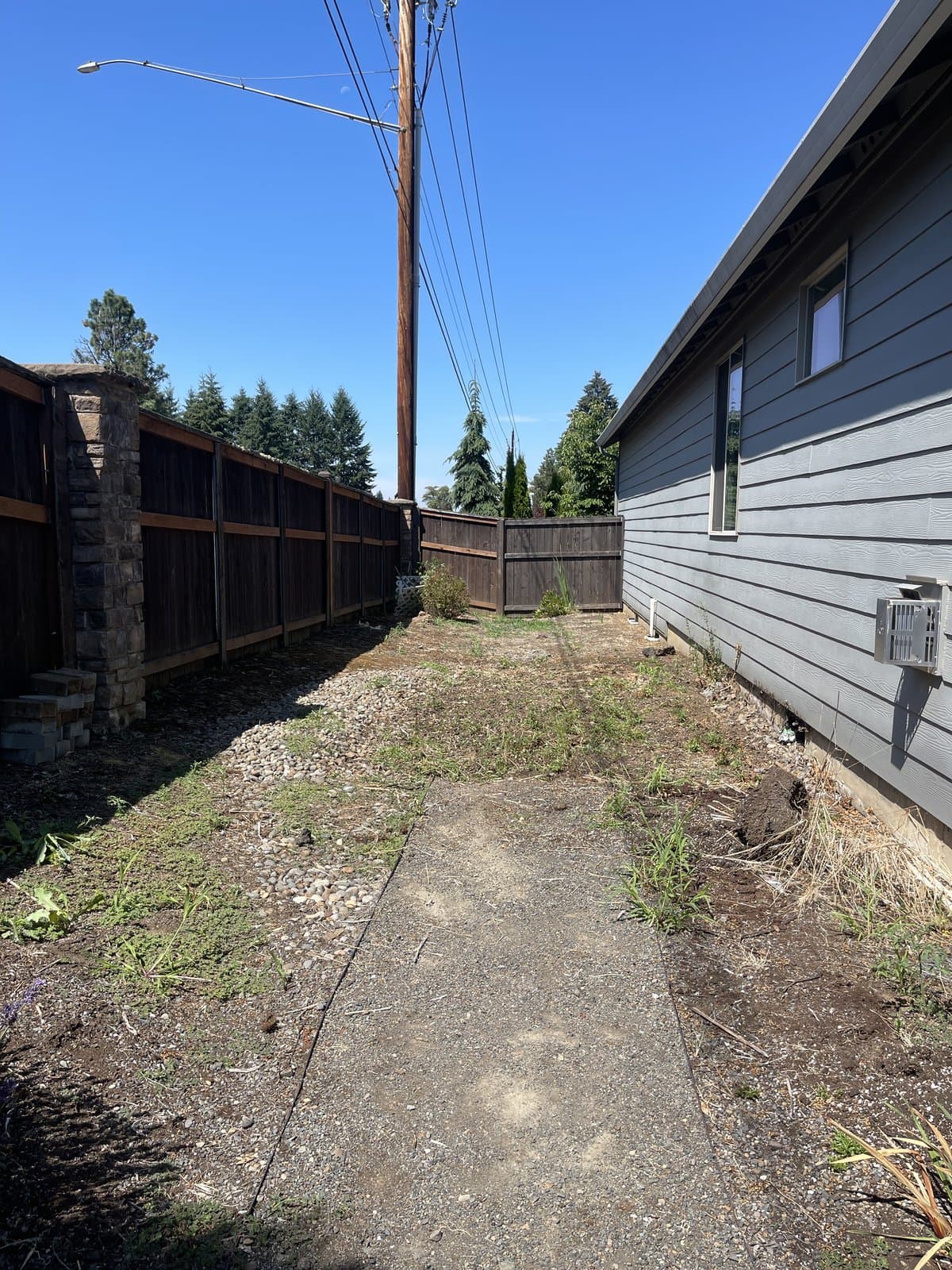 The same side yard cleared, swept, and open after Brisk demolition and haul-away
